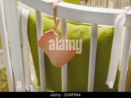 Baby birth tag on crib background, close up. Stock Photo