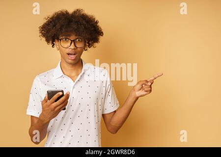 Amazed man with glasses indicates something with hand Stock Photo