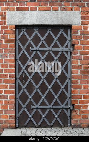 Old door with bars on a red brick background . Stock Photo
