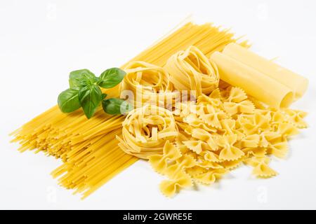 Various pasta with basil on white background Stock Photo