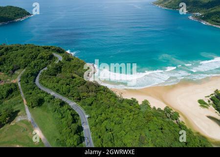 Aerial view of curve road along the Naiharn beach at Phuket Thailand beautiful sandy beach and open sea in summer season Nature recovered Environment