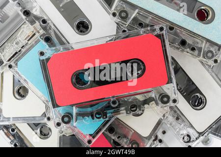Pile of vintage audio cassette recording tapes with red tape on top. Stock Photo