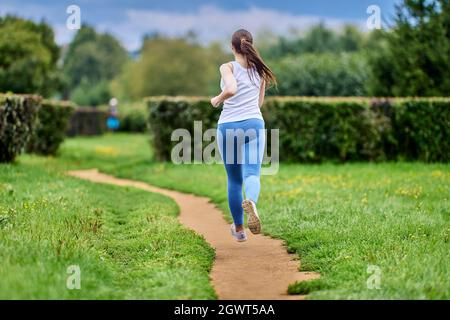 Rear view of woman who is coaching in park in sportswear. Stock Photo