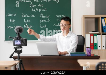 Asian teacher conducting English lesson online Stock Photo