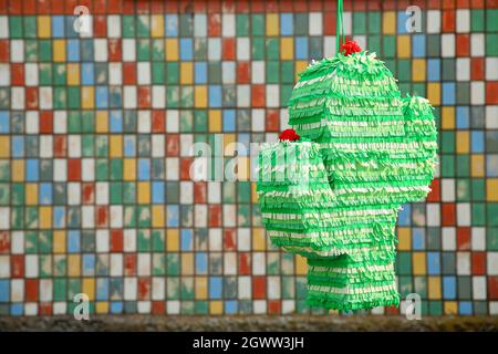 Mexican pinata in shape of cactus hanging outdoors Stock Photo