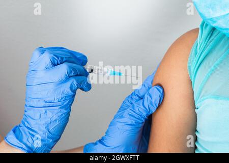 children's nurse about to administer the injection into the arm of a little brown girl. doctor injecting covid-19 vaccine. flu vaccine. medical concep Stock Photo