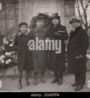 family reunion during the WW2 World war two, at Hungary. The son who is member of the hungarian army possibly is a photographer, that's why he is wearing a camera. Never know that he was a professional or just a hibby photographer. His parents ( Mother and father) and  his younger sister is very well dressed. A proper upper middle calss family. Period: 1940's Source: original photograph Stock Photo