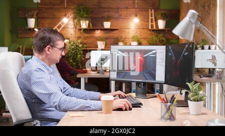 Game creator developing videogame simulation while working at level design using production software. Creative artist developer editing graphic montage in creative company office Stock Photo