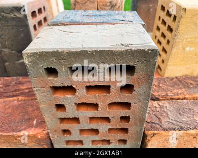 Different types of bricks stacked beautifully on green grass Stock Photo