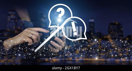 FAQ frequently asked questions concept. Hand touch white tablet with digital hologram question mark sign on city dark blurred background. Problem, nee Stock Photo