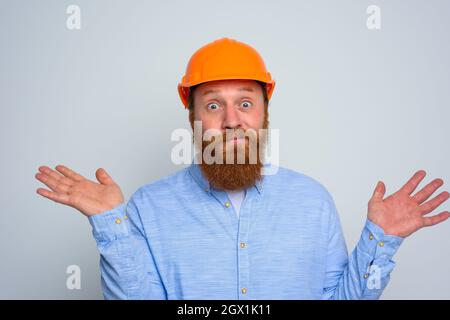 Isolated unsure architect with beard and orange helmet Stock Photo