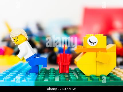 POZNAN, POLAND - Feb 15, 2019: A Lego toy of a Man running away from dynamite placed in front of a sleeping yellow duck Stock Photo