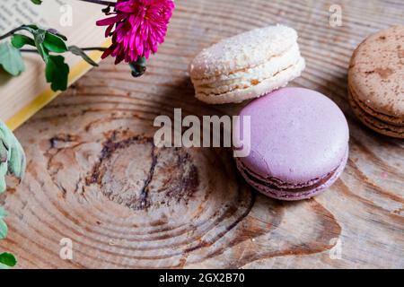 macarons on the background of the book, on a wooden table. horizontal frame. Aesthetics with macaroons and a book. Beautiful cakes on a wooden table Stock Photo