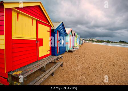 A storm front approaches the colorful, iconic beach huts on Brighton Beach near Melbourne in Victoria, Australia. Stock Photo