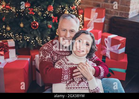 Photo of dream retired lover couple comfy embrace enjoy rest wear deer print pullover in decorated home indoors Stock Photo