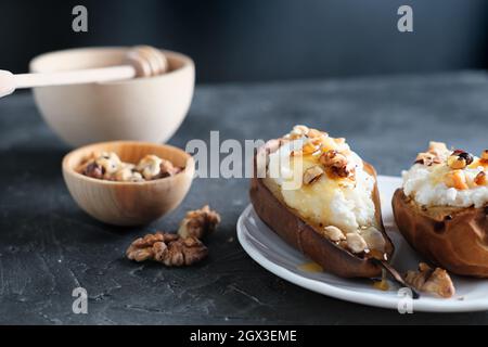 fall season comfort food. baked pears and ricotta with nuts and honey. warm dessert for autumn menu. dark grey background Stock Photo
