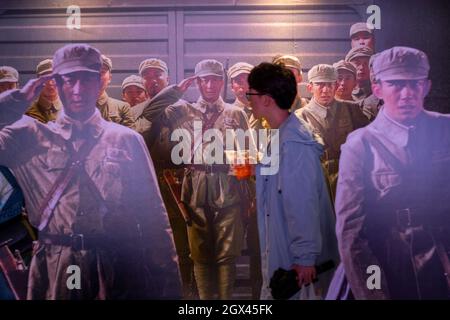 A man walks past the propaganda installation for the movie "The Battle at Lake Changjin" in a cinema in Beijing, China. 04-Oct-2021 Stock Photo