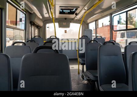 Leatherette seats in the empty cabin of a city public municipal bus. Stock Photo