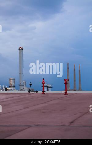 electric scooter and red telescope, tourist equipment, vacations, industrial landscape. Stock Photo