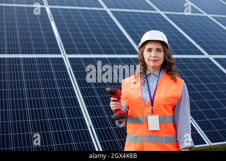 The woman electrician with screwdriver at the solar station Stock Photo