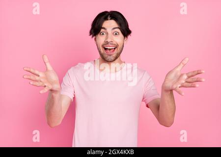 Photo portrait man wearing casual t-shirt inviting for party isolated pastel pink color background Stock Photo