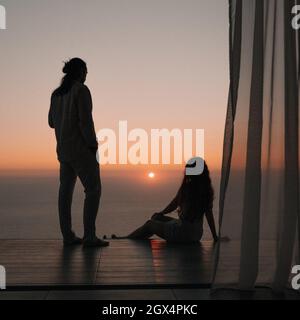 Silhouette of young couple enjoying beautiful sunset at the beach ...