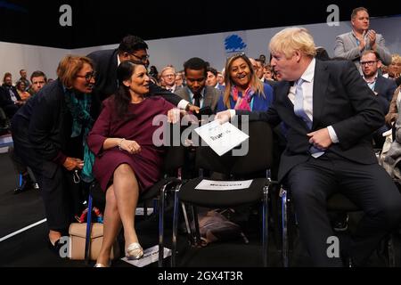 Home Secretary Priti Patel and Prime Minister Boris Johnson speak before Chancellor of the Exchequer Rishi Sunak addresses the Conservative Party Conference in Manchester. Picture date: Monday October 4, 2021. Stock Photo