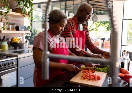 African american senior couple cooking together in kitchen Stock Photo