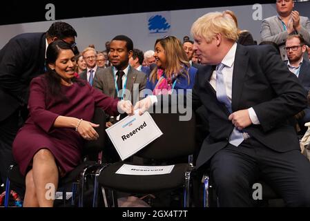 Home Secretary Priti Patel and Prime Minister Boris Johnson speak before Chancellor of the Exchequer Rishi Sunak addresses the Conservative Party Conference in Manchester. Picture date: Monday October 4, 2021. Stock Photo