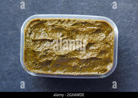 The wooden bowl with rehydrated henna on table Stock Photo