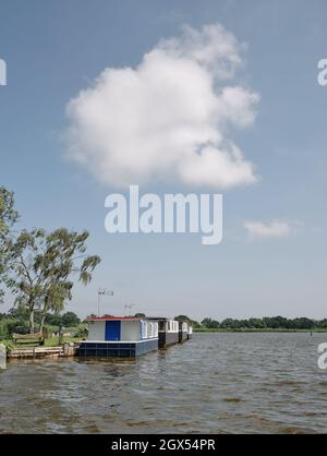 Moored house boats / houseboats on Hickling Broad on the Norfolk Broads, Norfolk England UK - Norfolk Broads summer landscape Stock Photo