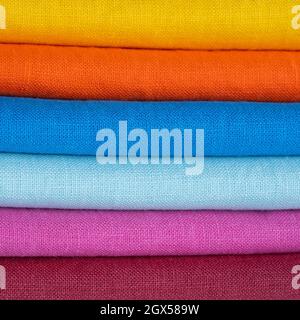 A stack of multi-colored bright linen fabric, close-up. Linen background. Fabric stripes Stock Photo