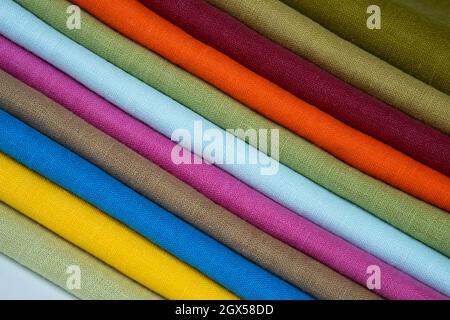 A stack of multi-colored bright linen fabric, close-up. Linen background. Fabric stripes Stock Photo