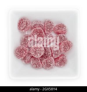 Top view of dark red gum drops with plum and cinnamon aroma in white bowl Stock Photo