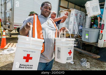 Everglades City Florida,after Hurricane Irma,emergency response recovery assistance distribution site,Red Cross worker volunteer Black man helping Stock Photo