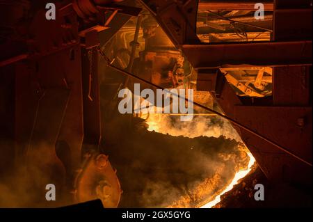 The process of tapping molten metal and slag from a blast furnace. Stock Photo