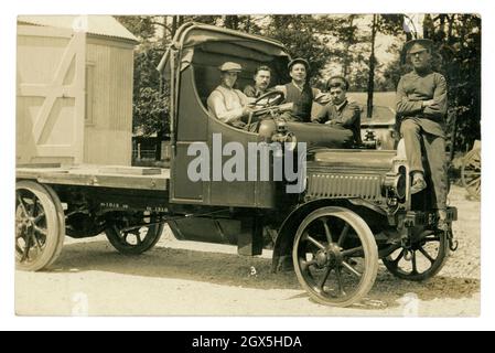 Original very clear WW1 era postcard of group young men from the Royal Flying Corps in a flatbed truck which was registered in Lancashire. Some of the men are in uniform with the RFC badge on their caps. On an army base with a hut or hangar, the wheels of a field gun can just be seen, perhaps these men were transporting artillery. circa 1917, U.K. Stock Photo