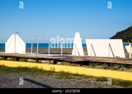 Abandoned white and wooden bathing structures on the sandy beach of Bocca di Magra, blue sky in autumn, between Liguria and Tuscany, Lunigiana, Italy Stock Photo