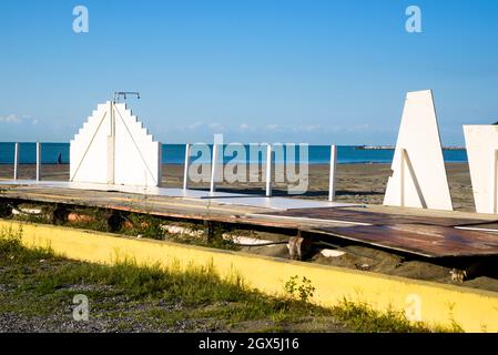 Abandoned white and wooden bathing structures on the sandy beach of Bocca di Magra, blue sky in autumn, between Liguria and Tuscany, Lunigiana, Italy Stock Photo