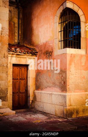 beautiful facade in orange and pink tones with door and window in medieval style Stock Photo