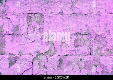peeled off old violet paint on flat rough brick wall surface - full frame background and texture Stock Photo
