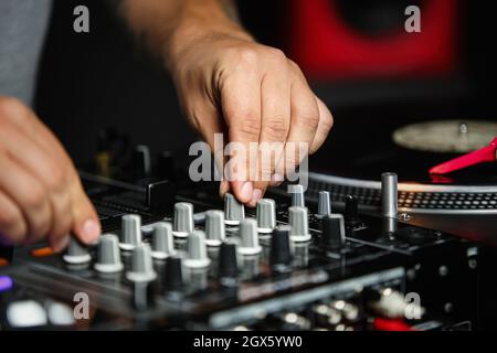 KYIV-28 JULY,2018: Hip hop Dj Ice mixes music tracks on sound mixer panel in night club.Professional party adjust frequency on mixing controller Stock Photo