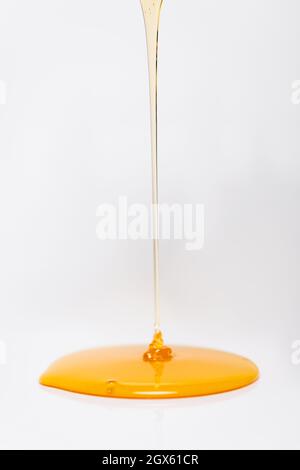 fresh honey flowing on white background with copy space Stock Photo