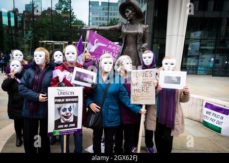 Manchester, UK. 04th Oct, 2021. People with placards attend the Women For State Pension Injustice Protest. People gather at the Emmeline Pankhurst statue in St Peters Square outside the Conservative Party Conference. The silent rally is a visual message to the government who appear reluctant to support the PHSOÕs findings of Maladministration.ÊAndy Barton/Alamy Live News Credit: Andy Barton/Alamy Live News Stock Photo