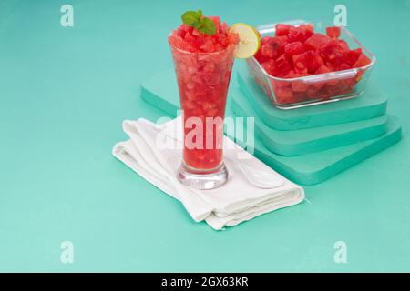 Watermelon Mojito ,watermelon with lemon and mint arranged in a white transparent glass and slices arranged in  a bowl with  background, isolated. Stock Photo