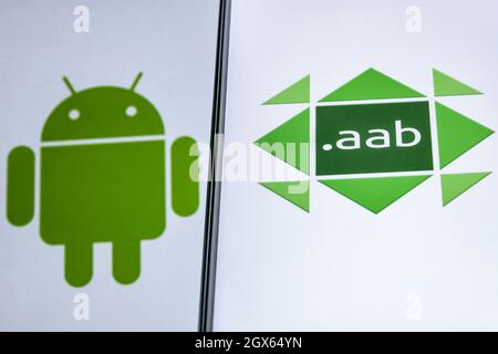 A smartphone with the AAB(Android App Bundle) logo. Android logo on the background. Stock Photo