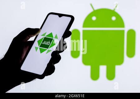 Android App Bundle (AAB) is a new application distribution format for Android. A smartphone with the AAB logo in a hand. Stock Photo