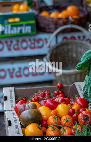 freshly picked tomatoes and vegetables in baskets outside of a country foods and greengrocers store. fresh fruits and vegetables for sale. Stock Photo