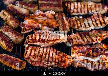 Closeup shot of grilling pork chops on a barbecue rack in the garden Stock Photo