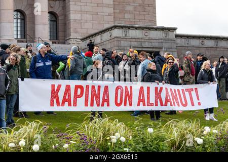 Protestors holding 'Kapina on alkanut!' banner in front of Parliament House in Helsinki, Finland Stock Photo
